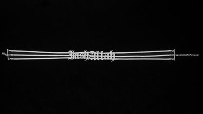 Silver InshAllah choker on a black backdrop.