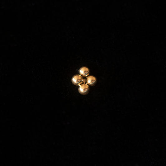 A gold stud against a black backdrop.