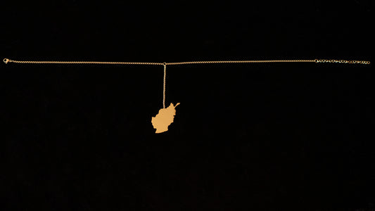 A map of Afghanistan hangs off a gold choker against a black backdrop.