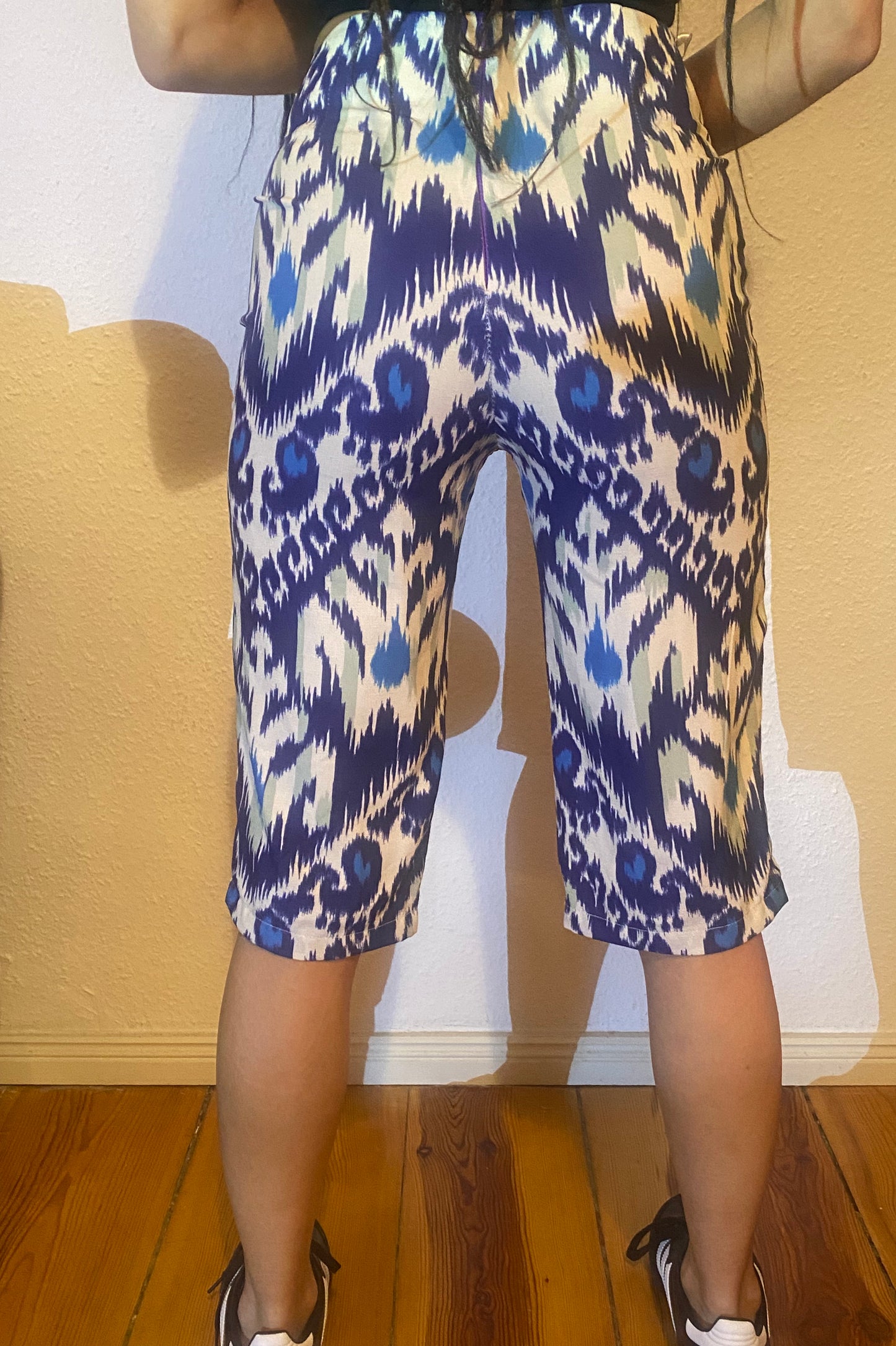 The backside of a woman in adras/ikat capris.