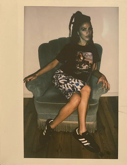 A polaroid of a woman wearing ikat capris, Adidas Sambas and a Titanic graphic tshirt.