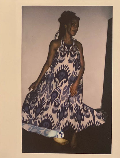 A polaroid of a woman dancing with an Uzbeki adras dress on.